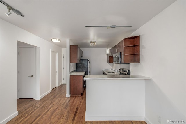 1245 Columbine St Unit 306, Denver, CO 80206 - kitchen featuring stainless steel appliances, open shelves, light countertops, wood finished floors, and a peninsula