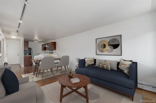 1245 Columbine St Unit 306, Denver, CO 80206 - living area featuring a baseboard radiator, wood finished floors, and rail lighting