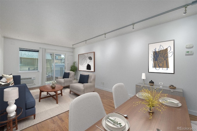 1245 Columbine St Unit 306, Denver, CO 80206 - living room featuring rail lighting, wood finished floors, and a wall mounted air conditioner