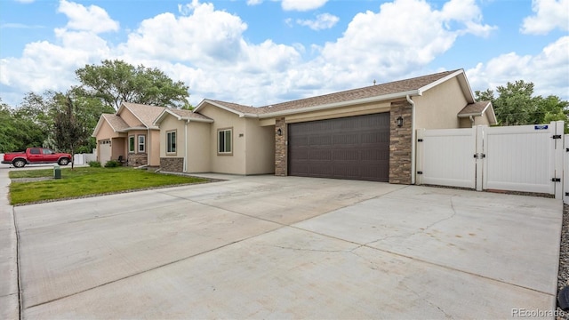 2891 Streamside Ave, Grand Junction, CO 81501 - single story home featuring a gate, a garage, driveway, stucco siding, and stone siding