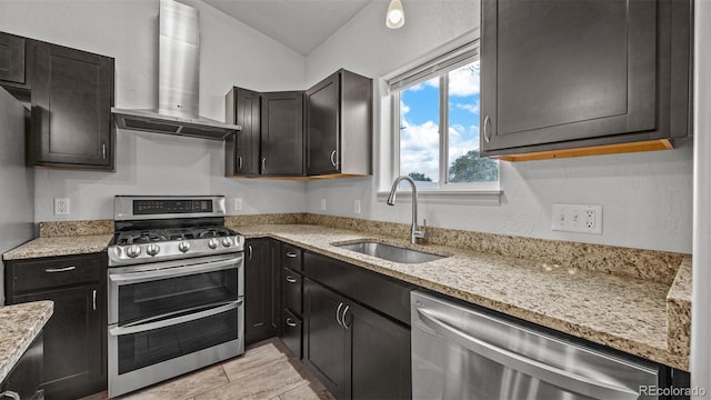 2891 Streamside Ave, Grand Junction, CO 81501 - kitchen with stainless steel appliances, wall chimney exhaust hood, a sink, light stone countertops, and dark cabinets