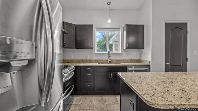 2891 Streamside Ave, Grand Junction, CO 81501 - kitchen featuring appliances with stainless steel finishes, a sink, light stone countertops, pendant lighting, and dark brown cabinetry