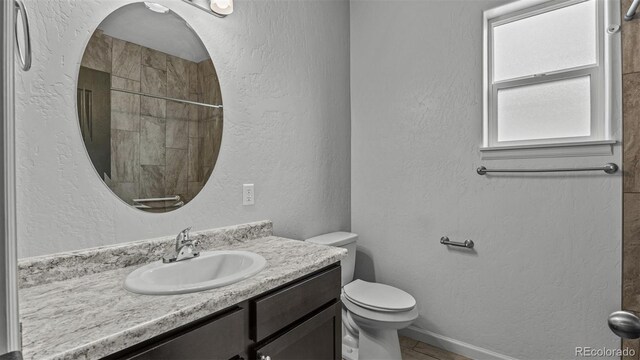 2891 Streamside Ave, Grand Junction, CO 81501 - bathroom featuring toilet, vanity, a tile shower, and tile patterned floors