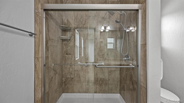 2891 Streamside Ave, Grand Junction, CO 81501 - bathroom with a shower stall, a textured wall, and toilet