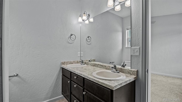 2891 Streamside Ave, Grand Junction, CO 81501 - full bath featuring double vanity, a textured wall, and baseboards