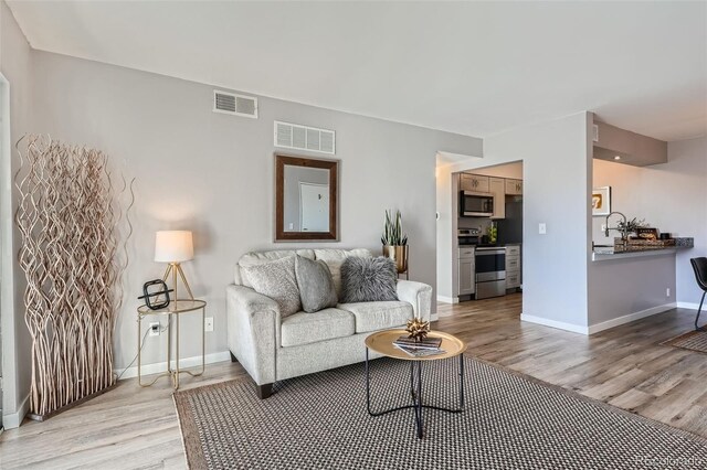 499 Wright St Unit 308, Lakewood, CO 80228 - living room with visible vents, baseboards, and light wood finished floors
