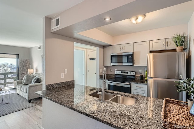 499 Wright St Unit 308, Lakewood, CO 80228 - kitchen with visible vents, dark stone counters, stainless steel appliances, light wood finished floors, and a sink