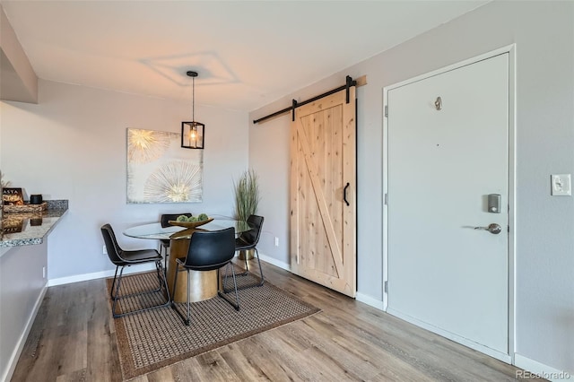 499 Wright St Unit 308, Lakewood, CO 80228 - dining area featuring baseboards, a barn door, and wood finished floors