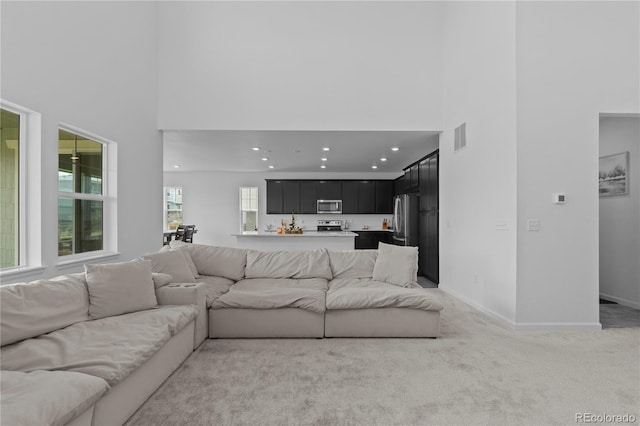 8550 Cheraw St, Littleton, CO 80125 - living room featuring a high ceiling, light carpet, and recessed lighting