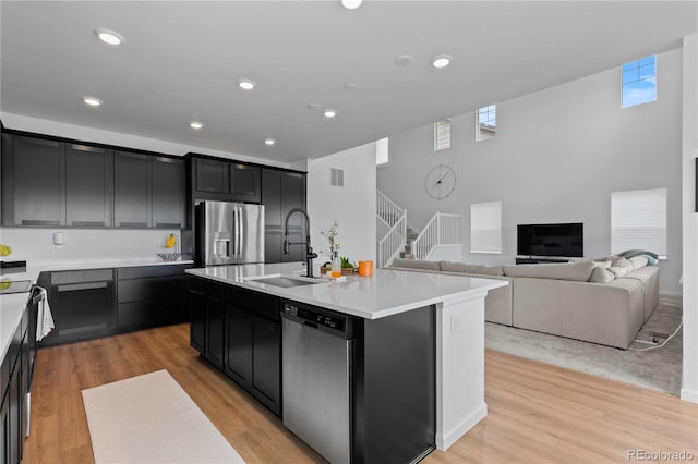8550 Cheraw St, Littleton, CO 80125 - kitchen with appliances with stainless steel finishes, dark cabinetry, light countertops, light wood finished floors, and recessed lighting