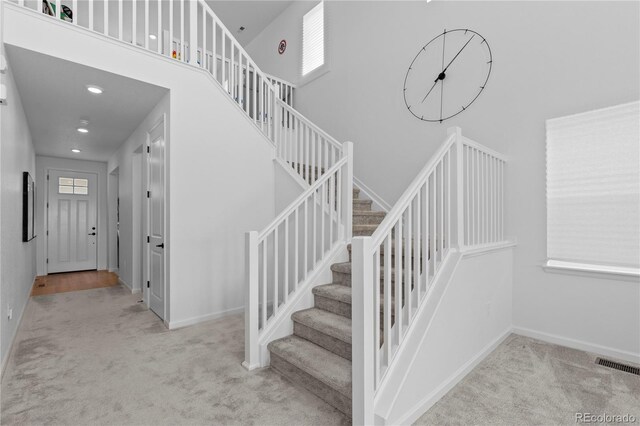 8550 Cheraw St, Littleton, CO 80125 - staircase with carpet, a towering ceiling, and recessed lighting