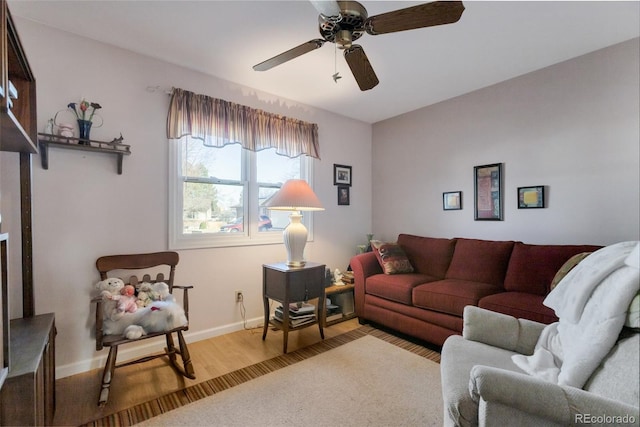 living room featuring baseboards, wood finished floors, and a ceiling fan