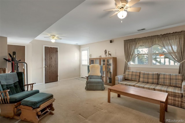 living room with visible vents, light colored carpet, baseboards, and ceiling fan