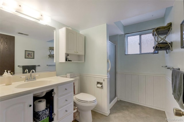 bathroom with visible vents, toilet, a shower stall, wainscoting, and vanity