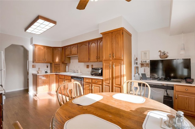 kitchen featuring wood finished floors, a ceiling fan, light countertops, dishwasher, and tasteful backsplash