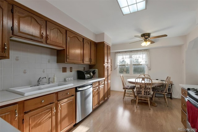 kitchen with a sink, stainless steel appliances, backsplash, and light countertops