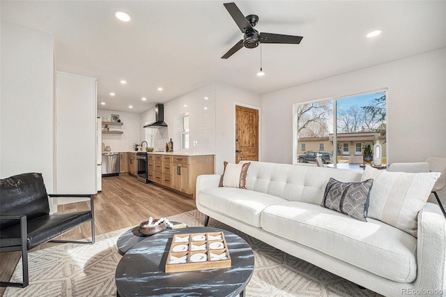 living room featuring ceiling fan and light hardwood / wood-style floors