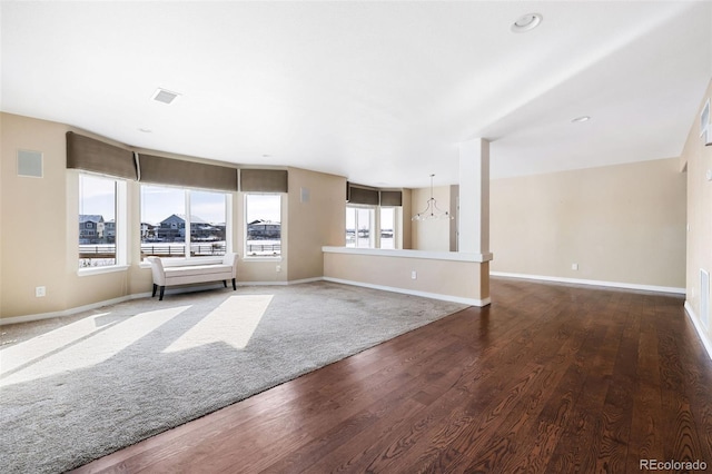 unfurnished living room with dark wood-type flooring and a wealth of natural light