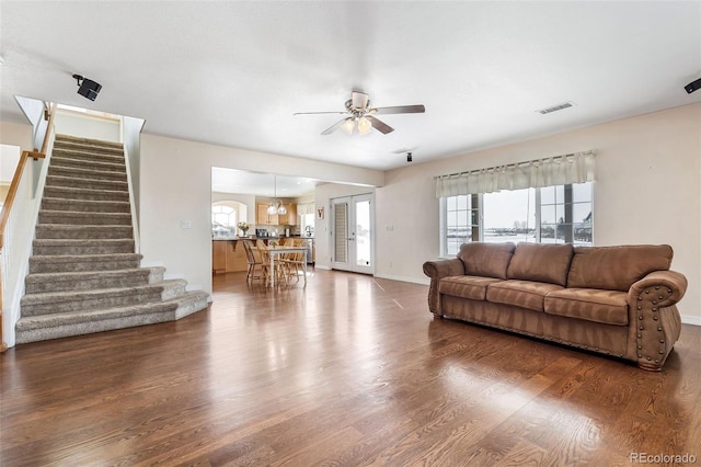 living room featuring ceiling fan and dark hardwood / wood-style floors