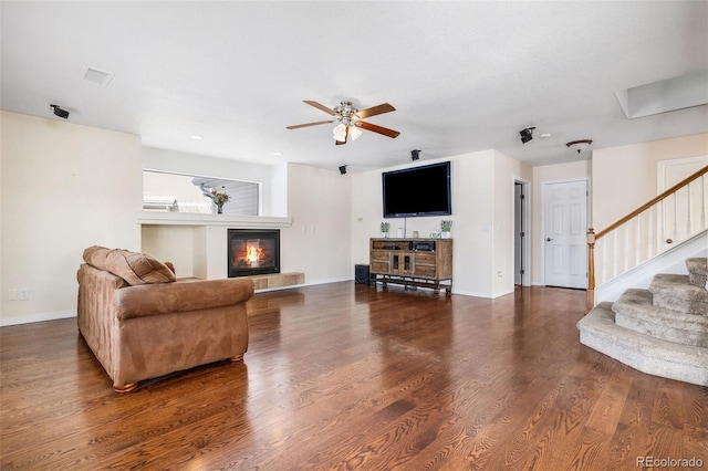 living room featuring ceiling fan and dark hardwood / wood-style floors