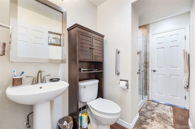 bathroom featuring sink, toilet, and an enclosed shower