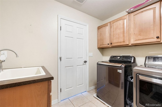 laundry area featuring sink, cabinets, washer and dryer, and light tile patterned floors