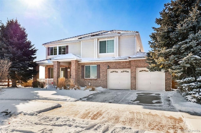 traditional home featuring driveway, a garage, and brick siding