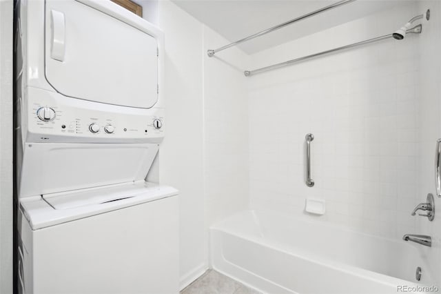 laundry area with light tile patterned floors and stacked washer / dryer