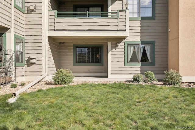 doorway to property featuring a yard and a balcony