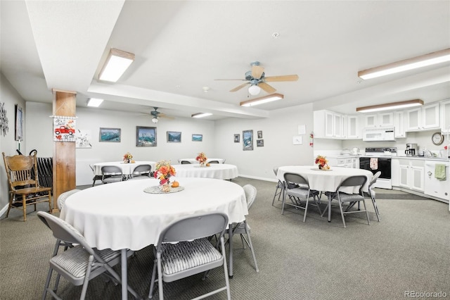 carpeted dining area with ceiling fan