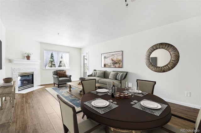 dining space with a fireplace and hardwood / wood-style floors