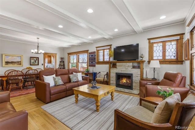 living room with beamed ceiling, a fireplace, light hardwood / wood-style flooring, and a notable chandelier