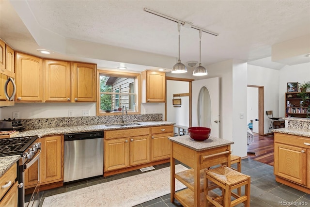 100 Moon Gulch Rd, Rollinsville, CO 80422 - kitchen featuring stainless steel appliances, light stone counters, track lighting, hanging light fixtures, and dark tile patterned flooring