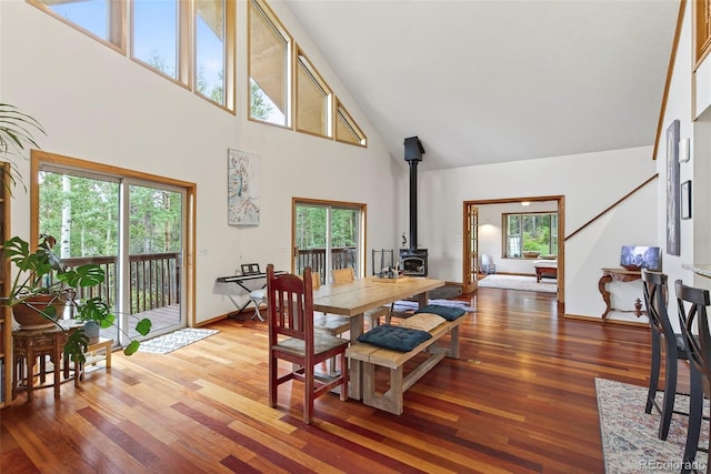 100 Moon Gulch Rd, Rollinsville, CO 80422 - dining space with high vaulted ceiling, a wood stove, and light wood-type flooring