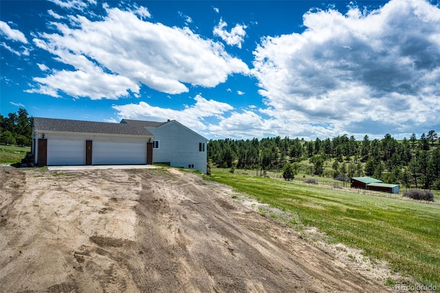 view of side of home with driveway and a garage