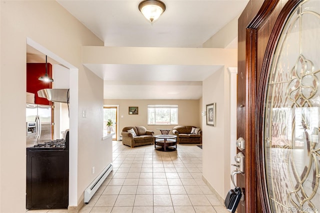 entryway featuring baseboard heating, light tile patterned flooring, and baseboards