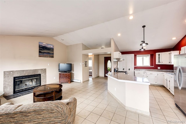 kitchen featuring open floor plan, stainless steel refrigerator with ice dispenser, light tile patterned flooring, a baseboard radiator, and lofted ceiling