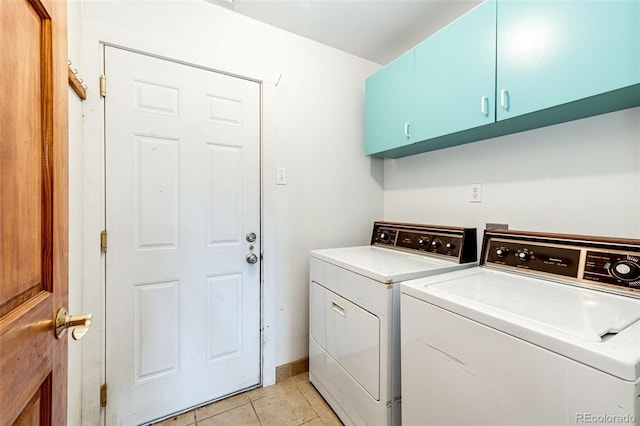 clothes washing area featuring cabinet space, washer and clothes dryer, light tile patterned floors, and baseboards