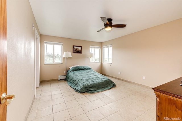 bedroom with multiple windows, a baseboard radiator, light tile patterned floors, and baseboards