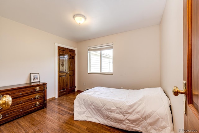bedroom with wood finished floors and baseboards