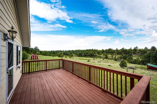 wooden terrace featuring a storage shed, an outdoor structure, and a yard