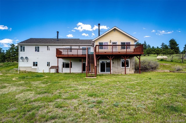 rear view of house with a deck, a lawn, and stairs