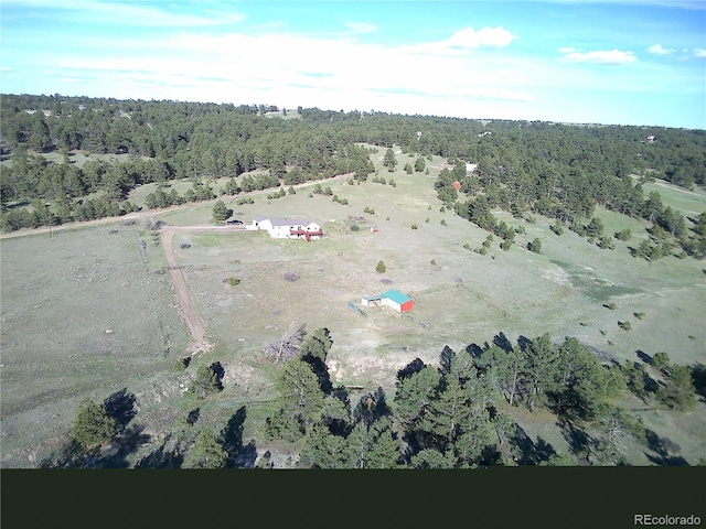 view of property location featuring rural landscape and a forest