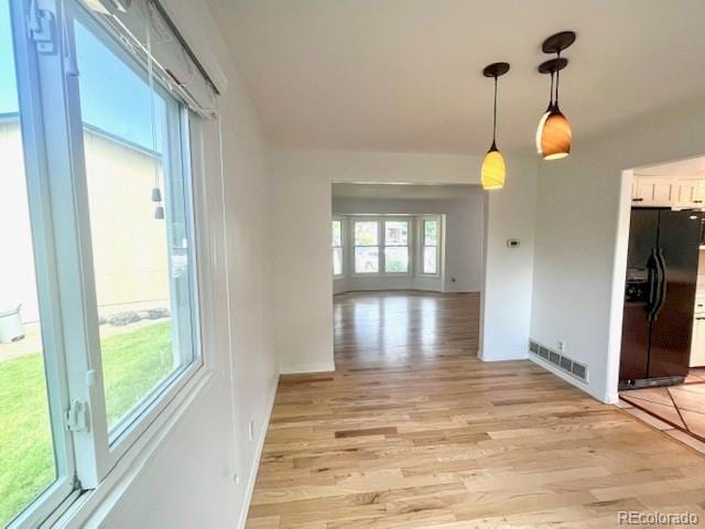 4753 S Gar Way, Littleton, CO 80123 - unfurnished dining area with light wood-type flooring and baseboards