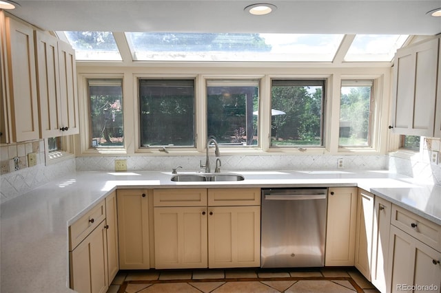 4753 S Gar Way, Littleton, CO 80123 - kitchen with stainless steel dishwasher, light countertops, light tile patterned flooring, and backsplash