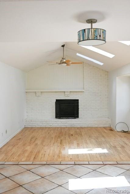4753 S Gar Way, Littleton, CO 80123 - unfurnished living room featuring a fireplace, vaulted ceiling, a ceiling fan, and wood finished floors
