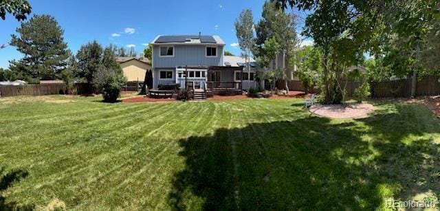 4753 S Gar Way, Littleton, CO 80123 - rear view of property with a fenced backyard, solar panels, and a deck