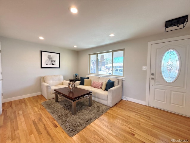 living room with light wood-style floors, baseboards, and recessed lighting