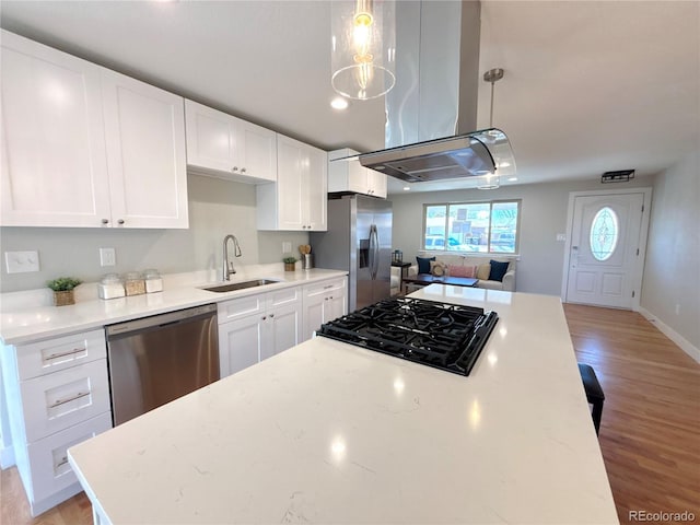 kitchen featuring light wood-style floors, appliances with stainless steel finishes, white cabinets, and a sink