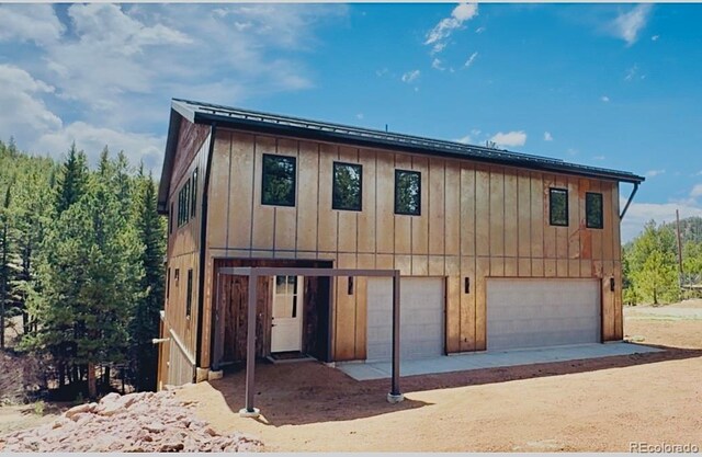 1282 N Crystal Rd, Lake George, CO 80827 - view of front of home with an attached garage, board and batten siding, and driveway